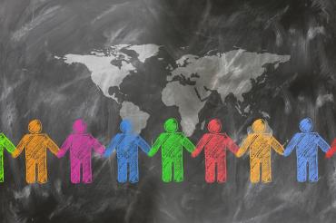 children holding hands around the earth