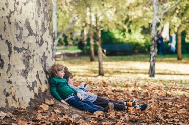 Children resting against a tree